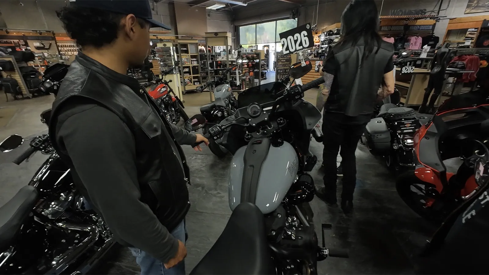 Rider in a leather vest checking out a new motorcycle at a dealership