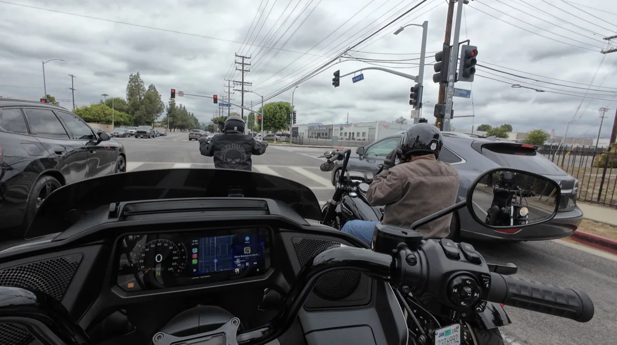 Rider view of motorcycles and cars stopped at a busy intersection