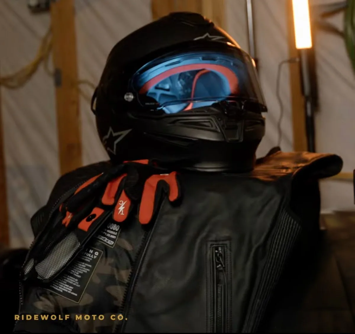Alpinestars S-R7 helmet, Tech-Air 3 leather airbag vest and red Thrashin gloves stacked on a bench