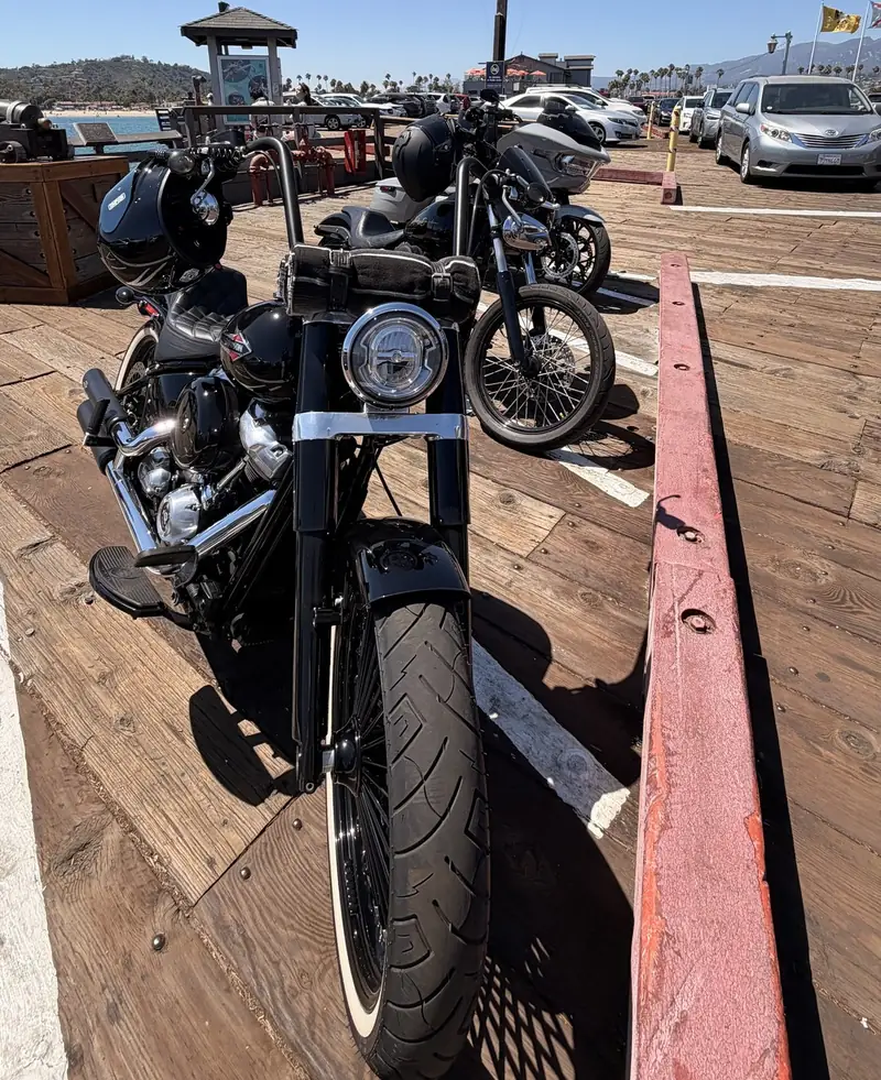 Motorcycles parked on a wooden boardwalk at a ride stop, helmets on the bars