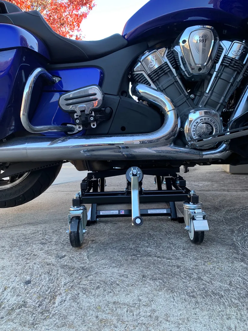 Rolling motorcycle lift under the engine of a blue Indian Pursuit